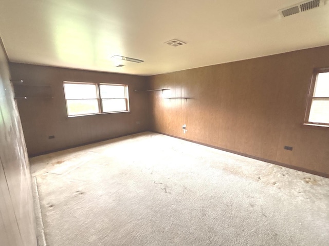 unfurnished room featuring plenty of natural light and carpet