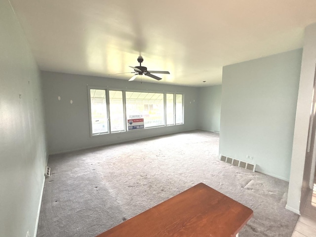 unfurnished living room with carpet floors and a ceiling fan