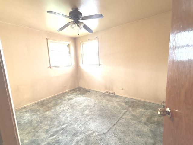 carpeted empty room with ceiling fan and baseboards
