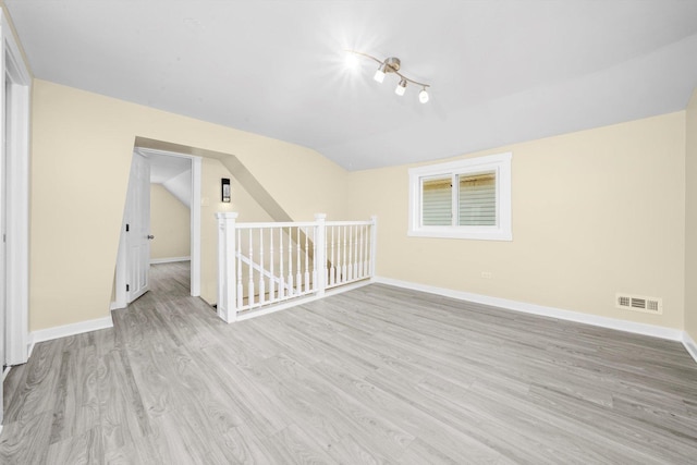 10617 S Wentworth Ave, Chicago, IL 60628 - unfurnished room featuring wood finished floors, vaulted ceiling, and rail lighting