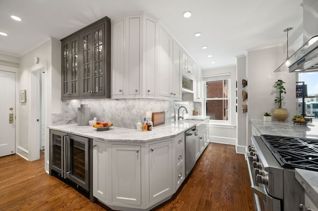 kitchen with island range hood, appliances with stainless steel finishes, a sink, beverage cooler, and ornamental molding