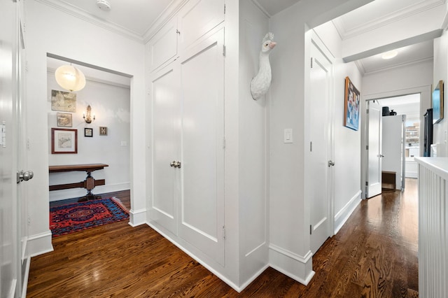 hallway with crown molding, baseboards, and dark wood-type flooring