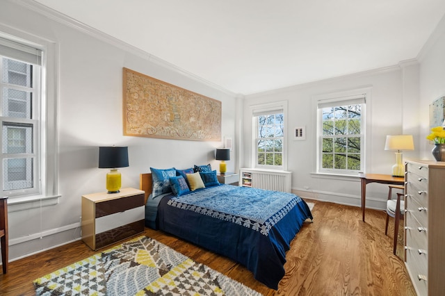 bedroom featuring radiator heating unit, baseboards, and crown molding