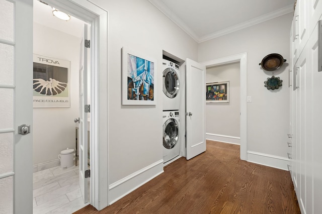 laundry area with laundry area, ornamental molding, baseboards, and stacked washing maching and dryer
