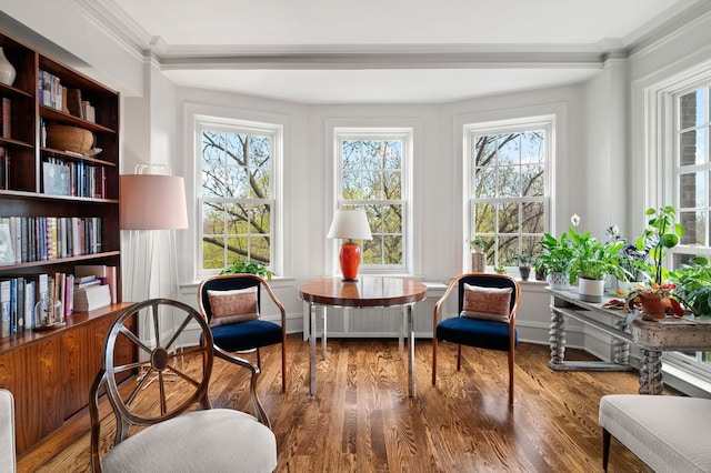 sitting room with crown molding, wood finished floors, and a wealth of natural light