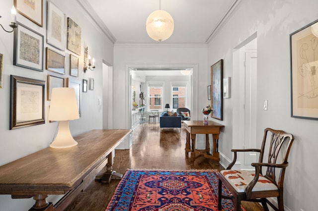 corridor with crown molding, baseboards, and wood finished floors