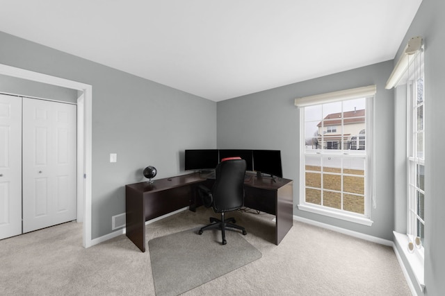 carpeted office space with plenty of natural light, visible vents, and baseboards