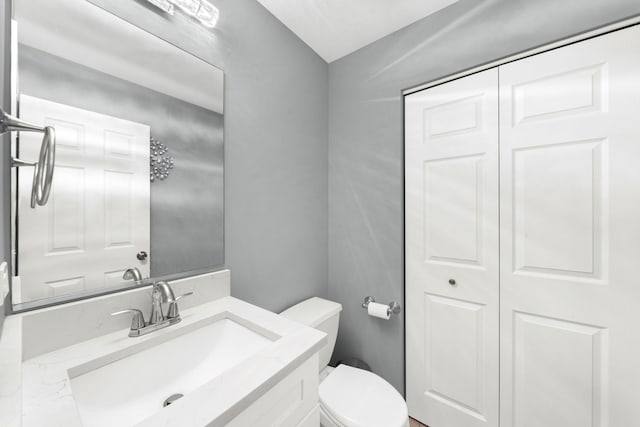 half bathroom with vanity and toilet