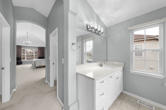 bathroom featuring lofted ceiling, visible vents, a chandelier, and a healthy amount of sunlight