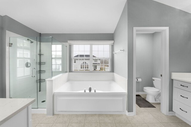 bathroom featuring tile patterned flooring, toilet, vanity, a garden tub, and a stall shower