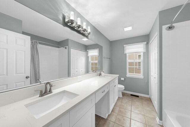 bathroom with toilet, tile patterned flooring, a sink, and double vanity