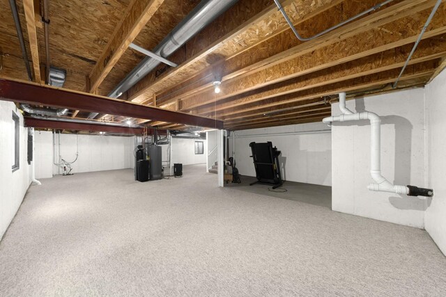 unfinished basement with water heater and stairway