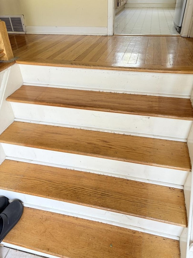 staircase featuring visible vents and hardwood / wood-style floors