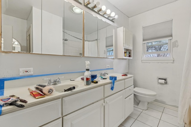 bathroom with double vanity, toilet, tile patterned floors, and a sink
