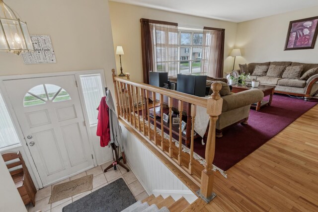 foyer entrance featuring a notable chandelier, stairs, wood finished floors, and a wealth of natural light