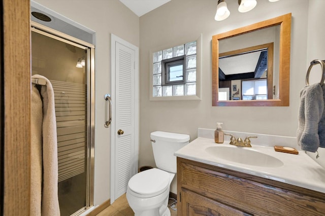 bathroom with tile patterned flooring, a closet, toilet, vanity, and a stall shower