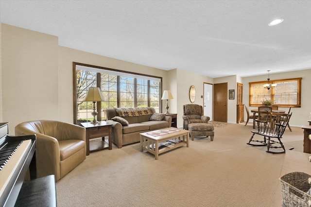 living area featuring recessed lighting, light colored carpet, a chandelier, and a healthy amount of sunlight
