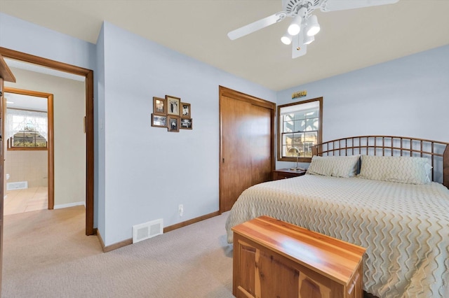 bedroom featuring light colored carpet, visible vents, and multiple windows