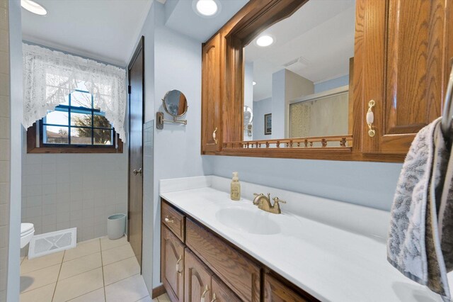 full bathroom featuring vanity, tile patterned floors, toilet, a stall shower, and visible vents