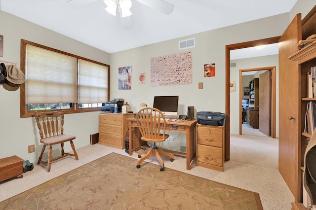 office area with visible vents, ceiling fan, and light carpet