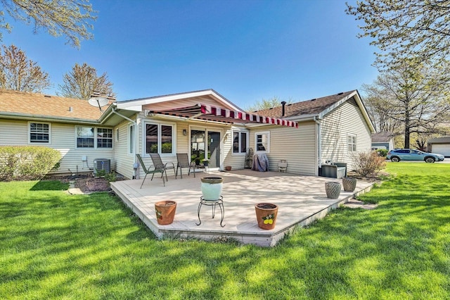 rear view of house featuring a patio, a yard, and central AC unit
