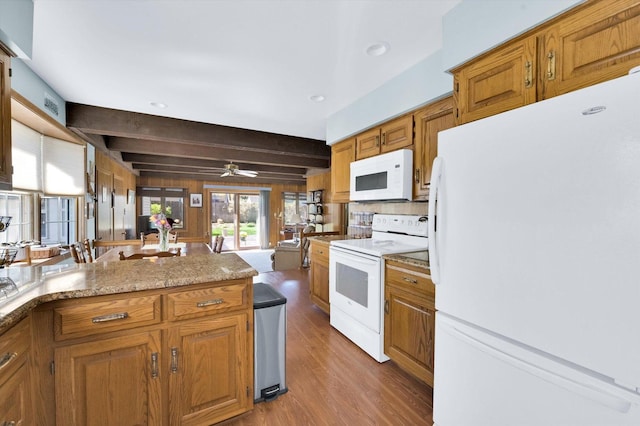 kitchen with beam ceiling, wood finished floors, white appliances, a ceiling fan, and brown cabinetry
