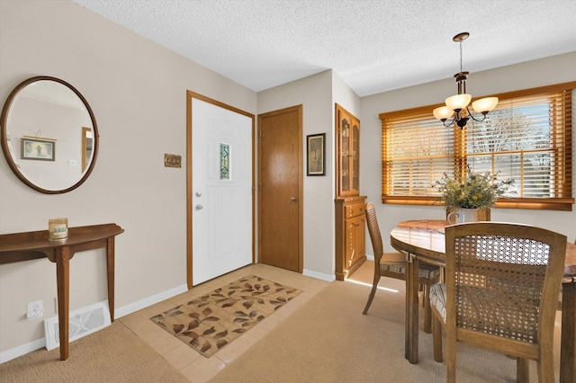dining room with a chandelier, visible vents, light carpet, baseboards, and a textured ceiling