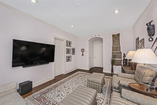 living area with crown molding, wood finished floors, arched walkways, baseboards, and recessed lighting