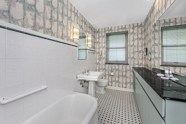 bathroom with a bath, toilet, tile patterned floors, and a sink