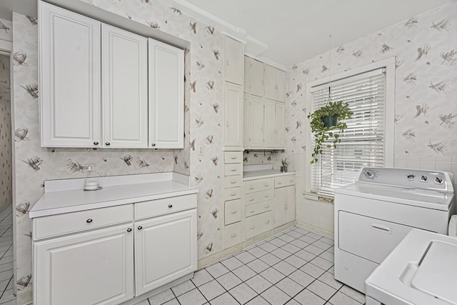 clothes washing area featuring cabinet space, light tile patterned flooring, wallpapered walls, and independent washer and dryer