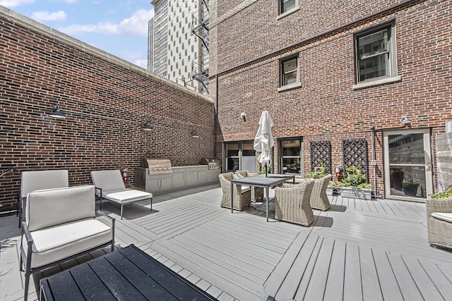 wooden deck featuring outdoor dining area, a grill, and exterior kitchen