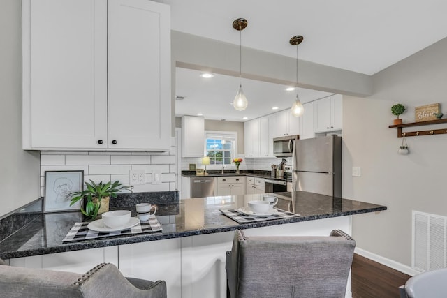 104 E Winchester Rd Unit E, Libertyville, IL 60048 - kitchen with stainless steel appliances, dark wood-type flooring, white cabinets, a peninsula, and recessed lighting