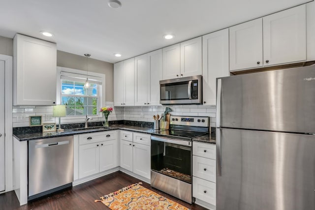104 E Winchester Rd Unit E, Libertyville, IL 60048 - kitchen featuring stainless steel appliances, a sink, dark wood-style flooring, white cabinetry, and backsplash
