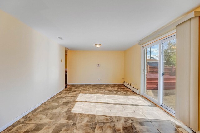 unfurnished room featuring a baseboard heating unit and baseboards