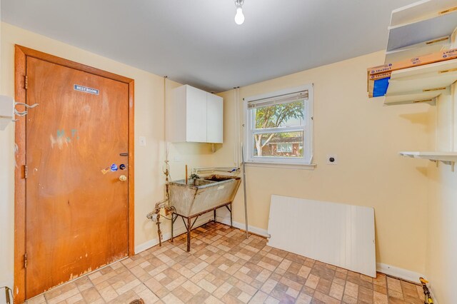 foyer entrance featuring radiator heating unit, baseboards, and brick patterned flooring
