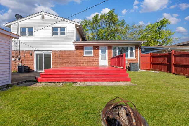 back of property featuring brick siding, a wooden deck, and central AC