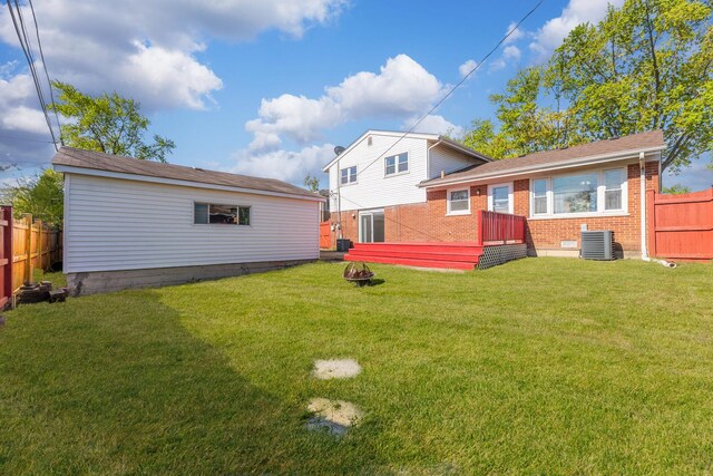 rear view of house featuring brick siding, central air condition unit, and an outdoor fire pit
