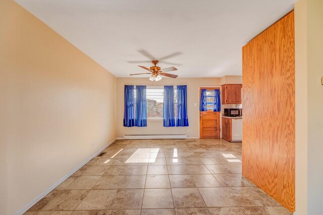 empty room featuring a baseboard heating unit, baseboards, and a ceiling fan