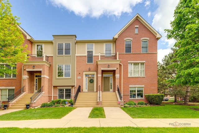 1123 E Port Clinton Rd, Vernon Hills, IL 60061 - townhome / multi-family property featuring brick siding, a front yard, and a balcony