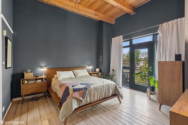 bedroom featuring wood ceiling, access to outside, beamed ceiling, hardwood / wood-style flooring, and a towering ceiling