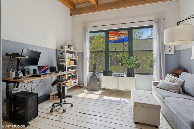 office featuring hardwood / wood-style floors and beam ceiling