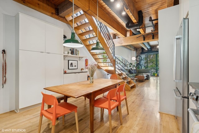 dining room featuring light wood-style flooring, stairs, wood ceiling, and beamed ceiling