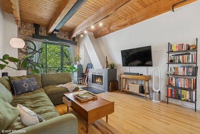 living room featuring wooden ceiling, wood finished floors, beamed ceiling, rail lighting, and a large fireplace