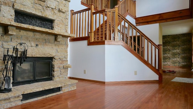 2346 W Longhollow Rd, Elizabeth, IL 61028 - unfurnished living room with a fireplace, hardwood / wood-style floors, baseboards, and stairway