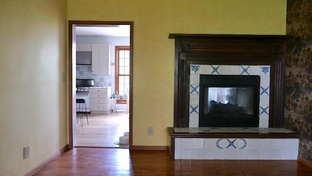 2346 W Longhollow Rd, Elizabeth, IL 61028 - detailed view of stainless steel stove, wood finished floors, and baseboards