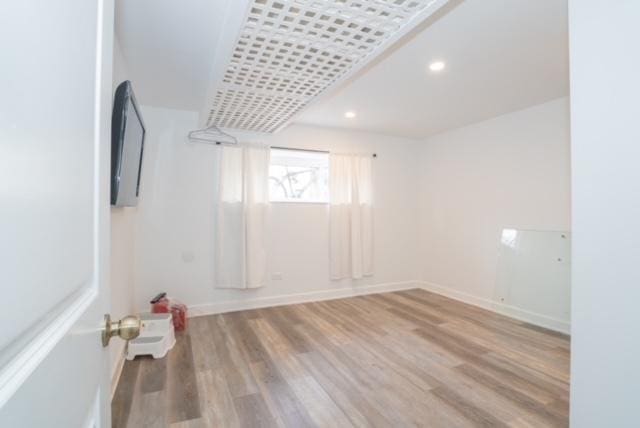 unfurnished room with baseboards, recessed lighting, and wood finished floors