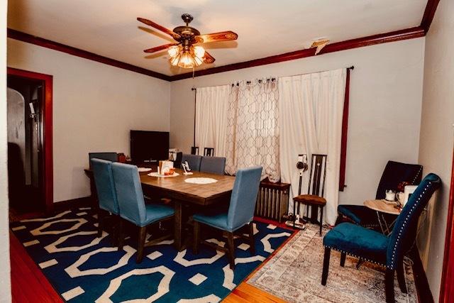 dining space with crown molding, ceiling fan, and wood finished floors
