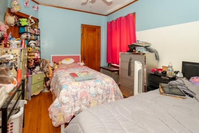 bedroom featuring ornamental molding, ceiling fan, and wood finished floors