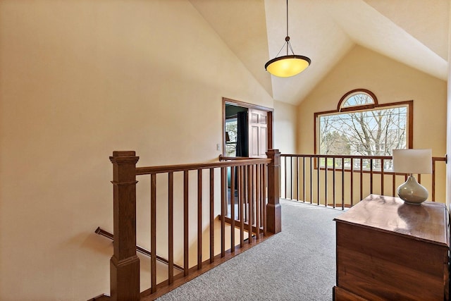 hall featuring an upstairs landing, carpet, and high vaulted ceiling