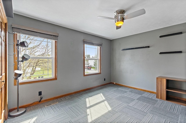 spare room featuring baseboards and ceiling fan